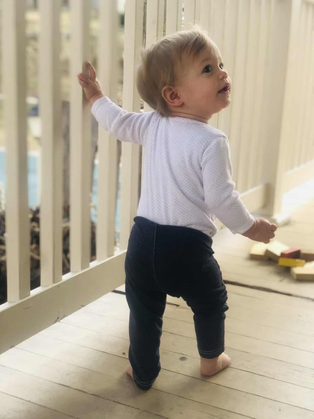 toddler standing by a railing